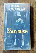 Charlie Chaplin's "The Gold Rush" movie poster features Chaplin in character standing before a mine entrance.
