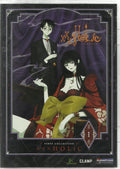 The XXXHOLiC anime DVD cover shows Yuko, in a red dress and large yellow bow, lounging while Watanuki, in a black suit, stands behind her.
