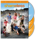The DVD cover for Shameless Season 2 shows the Gallagher family playfully spraying each other with water from a fire hydrant amidst strewn beer bottles.
