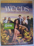 "Weeds Season Two DVD cover features Mary-Louise Parker and the cast in a field of sunflowers for the Showtime comedy series."
