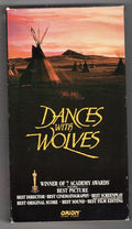 Viewers see the vintage VHS cover for the Academy Award-winning film "Dances with Wolves" showing a Native American village at sunset.
