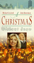 Movie poster promotes "A Christmas Without Snow" starring Michael Learned and John Houseman, featuring a city skyline, candlelight vigil, and inset portraits of the actors.
