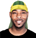 Smiling man showcases his yellow and green silky durag for wave styling.

