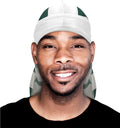 Smiling man wears a green and white silk durag.
