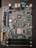 Close-up shows a green Dell computer motherboard displaying various components including the CPU socket, RAM slots, and expansion ports.
