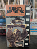 Artwork displays the vintage VHS cover for "Mighty Joe Young," featuring a gorilla lifting a platform with a woman at a piano.
