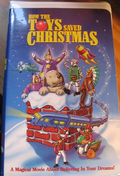 The VHS cover for "How the Toys Saved Christmas" features toys on a chimney as a train and toy soldiers celebrate a magical holiday movie.
