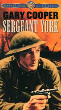 Gary Cooper, as Sergeant York, holds a pistol, looking determined against a war-torn battlefield on the Warner Bros. movie poster.
