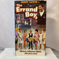Jerry Lewis stars in "The Errand Boy" VHS cover art featuring the comedian with his tongue out surrounded by women and gifts.
