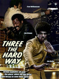 Movie poster for "Three the Hard Way" features Fred Williamson aiming a gun, Jim Brown brandishing a weapon, and Jim Kelly doing a martial arts pose in front of a cityscape.
