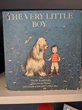Vintage children's book cover features a little boy holding the leash of his large, furry sheepdog in a field of grass and mushrooms.
